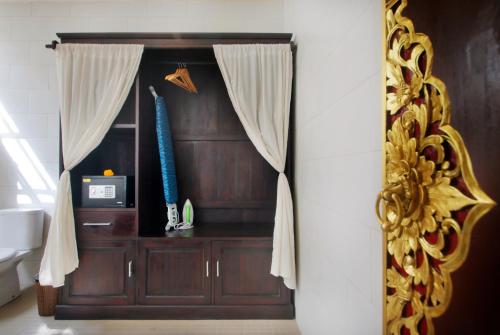 KetewelGraha Madesimon的配有带窗帘的木柜的房间