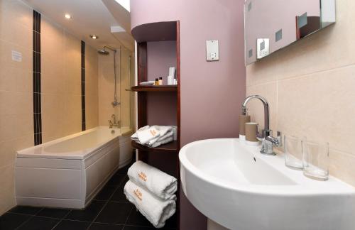 布里奇诺斯Ye Olde Punchbowl Country Inn & Gardens的一间带水槽、浴缸和卫生间的浴室
