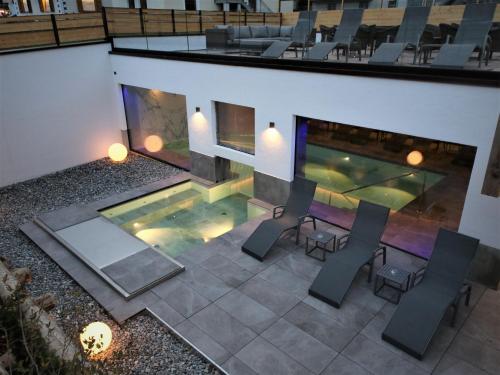 利维尼奥康科迪亚酒店的享有带椅子和壁炉的游泳池的顶部景致