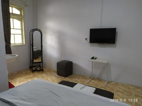 DoboPenginapan APEX的卧室配有一张床,墙上配有电视。