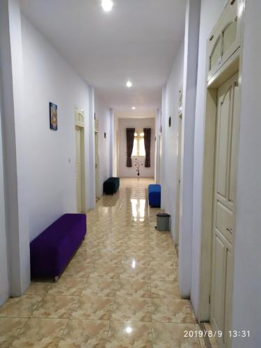 DoboPenginapan APEX的走廊设有白色的墙壁和蓝色的沙发
