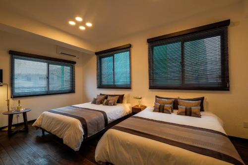 宜野湾市Ginowan - House / Vacation STAY 46771的带2扇窗户的客房内的2张床