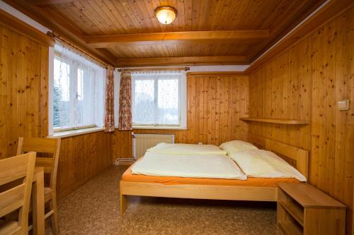 捷克布杰约维采U Kapličky的木制客房内的一间卧室,配有一张床