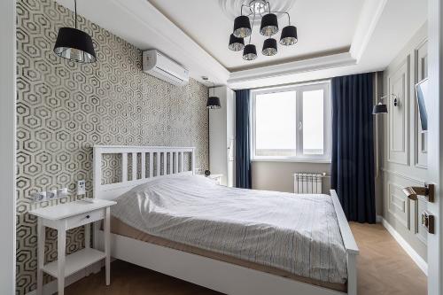 下瓦尔托夫斯克Апартаменты Архитектор на набережной的卧室配有白色的床和窗户。