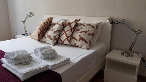 波尔图布拉加斯一室公寓的一张带两条毛巾和两盏灯的床