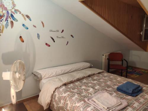 特鲁埃尔Villa CiTe- jardines/BBQ/terrazas/ para familias的一间卧室配有一张床、风扇和楼梯。