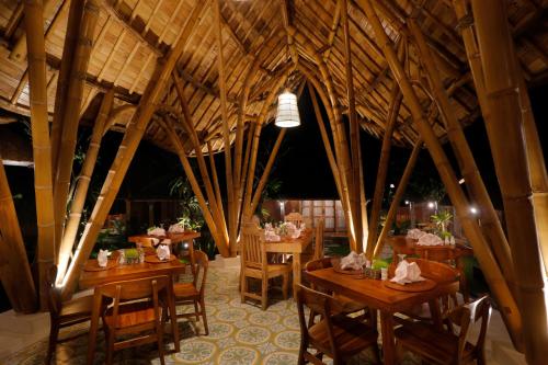 Bangli巴厘岛乌玛传统生态旅馆的一间设有木桌和椅子的餐厅