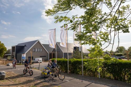 尼维莱特巴德Zonneweelde, Vakantie aan Zee的一群人骑着自行车沿着街道走