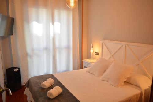萨拉曼卡Apartamento Edificio Plaza Gran Vía的一间卧室配有一张床,上面有两条毛巾