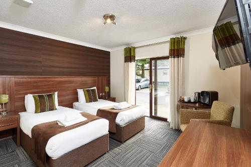 圣玛格丽特克利夫圣玛格丽特酒店的酒店客房设有两张床和一张桌子。