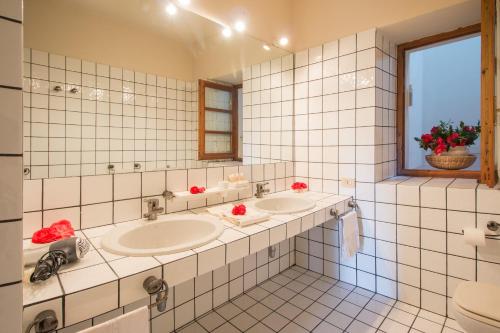 马斯诺维斯康蒂卡萨马瑞恰酒店的白色瓷砖浴室设有两个盥洗盆和窗户