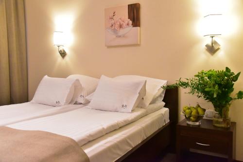 新托梅希尔高保真音响Spa酒店的一间卧室配有带白色床单和枕头的床。