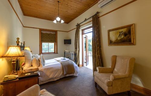 斯泰伦博斯长青庄园Spa宾馆的卧室配有床、椅子和窗户。
