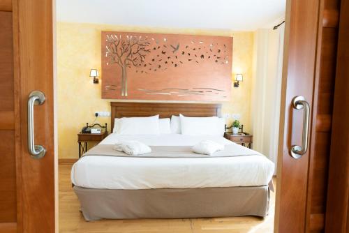 卡兰克克蒙达德酒店的一间卧室配有一张大床和两条毛巾