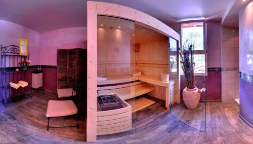 埃姆布能Logis Hotel-Restaurant Spa Le Lac的大型客房设有浴缸和椅子。