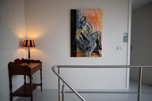 莱米尔Beach Suites Lemmer的一张桌子旁墙上的画,带灯