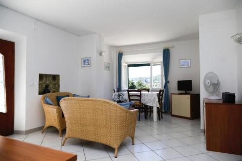 坎普码头VILLA ANNA Appartamenti per vacanza in casale di charme的客厅配有藤椅和桌子