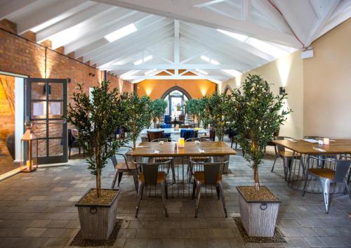 法利The Bay Filey的一间设有桌椅和盆栽树木的餐厅