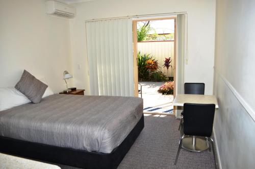 雷德兰湾勒德兰德湾汽车旅馆的卧室配有1张床、1张桌子和1把椅子