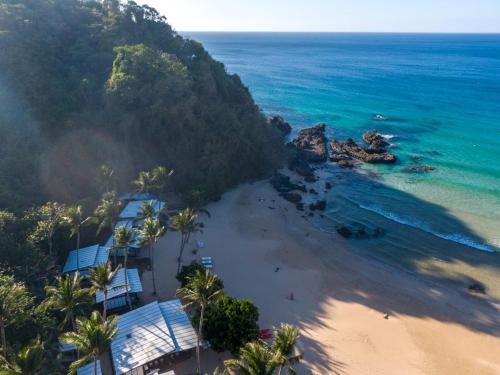 爱妮岛Duli Beach Resort的享有棕榈树海滩和大海的空中景致