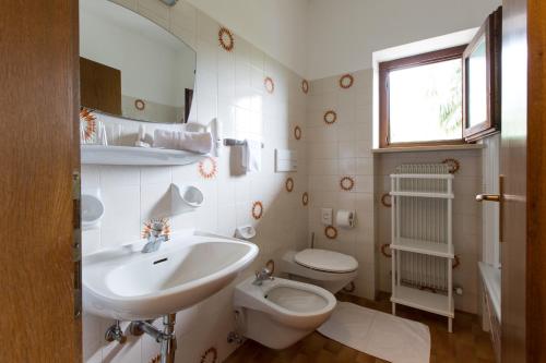 梅拉诺Pension Sankt Urban的白色的浴室设有水槽和卫生间。