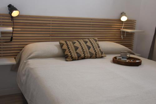 法维尼亚纳Lanterna sul mare的一张带木制床头板的床和一个托盘