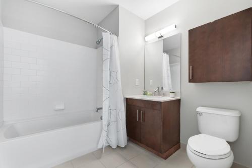 泽西市Global Luxury Suites Downtown Jersey City的浴室配有卫生间、浴缸和水槽。