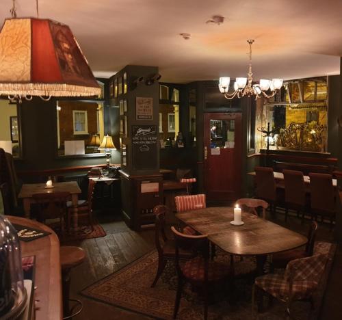 彻特西奥尔德天鹅酒店的一间带桌椅和吊灯的餐厅