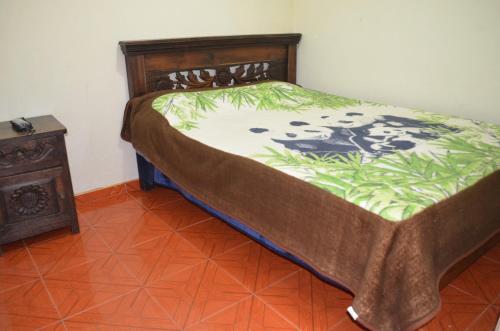 El CocuyHotel la Cabaña的一间卧室配有一张床和一个床头柜