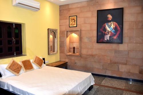 焦特布尔Jodhpur Palace Guest House的一间设有两张床的客房,墙上挂着一幅画
