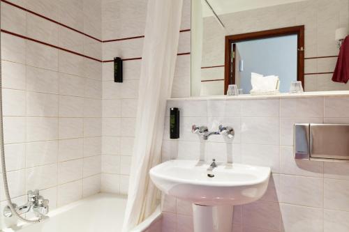 阿姆斯特丹尼勃曼果利亚酒店的白色的浴室设有水槽和镜子