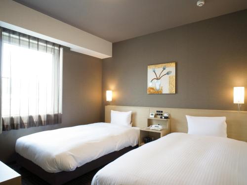 Ōfunato鲁特奥范纳图酒店的酒店客房设有两张床和窗户。