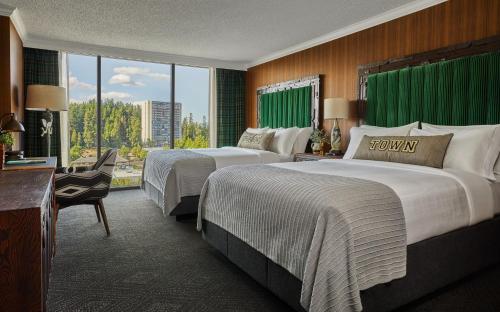 尤金Graduate Eugene的酒店客房设有两张床和大窗户。