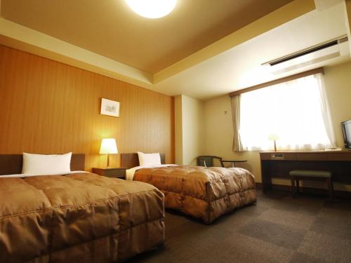 高崎高崎益尼斯古奇鲁特旅馆的酒店客房设有两张床和窗户。