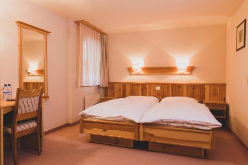 琪纳尔岳罗普酒店的一间卧室配有一张床、一张书桌和一面镜子