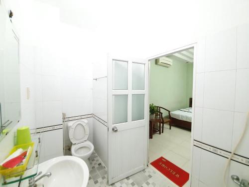 胡志明市Khách sạn Trường Sơn的一间带卫生间、水槽和镜子的浴室