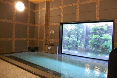 敦贺市敦贺站前路线酒店的游泳池,浴室内配备了大电视