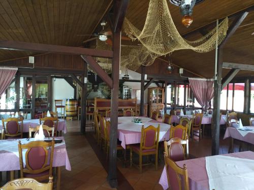 NašicePansion Ribnjak的餐厅设有桌椅和粉红色的桌椅