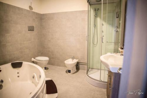纳托Hotel Lonatino的带浴缸、卫生间和淋浴的浴室。