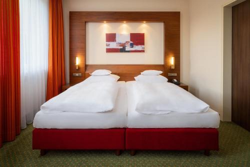 上乌瑟尔陶纳斯公园酒店的两间带红色窗帘的酒店客房