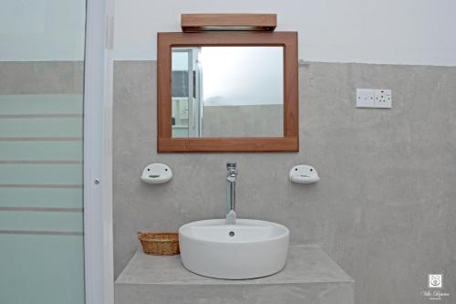 班德勒韦勒Villa Perpetua的浴室设有白色水槽和镜子