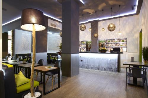 塞萨洛尼基城市酒店的一间带桌椅的餐厅和一间酒吧