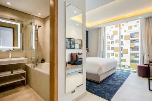 卡萨布兰卡Aparthotel Adagio Premium Casablanca City Center的带浴缸的浴室和1间带1张床的卧室