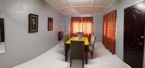 日得拉Jitra homestay的用餐室配有黄色的桌子和椅子