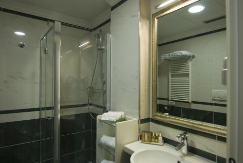 巴里JR Hotels Oriente Bari的一间带水槽、淋浴和镜子的浴室