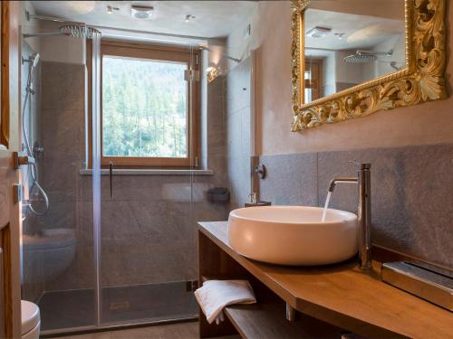 布勒伊-切尔维尼亚3 Chalets Aparthotel的一间带水槽、淋浴和镜子的浴室