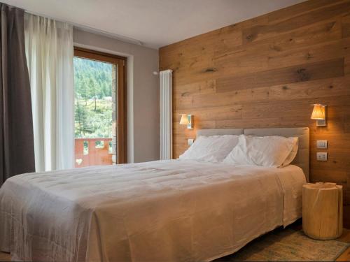 布勒伊-切尔维尼亚3 Chalets Aparthotel的一间卧室设有一张大床和大窗户