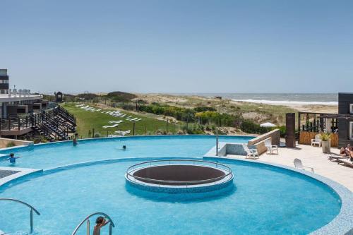 马德拉潘帕斯Linda Bay Premium Resort的一座大型游泳池,其背景是海滩