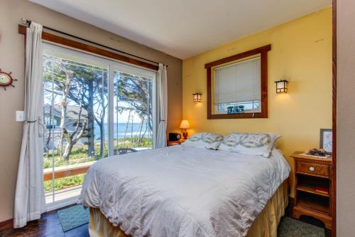 Holiday BeachOregon Bed n' Beach的一间卧室设有一张床和一个大窗户
