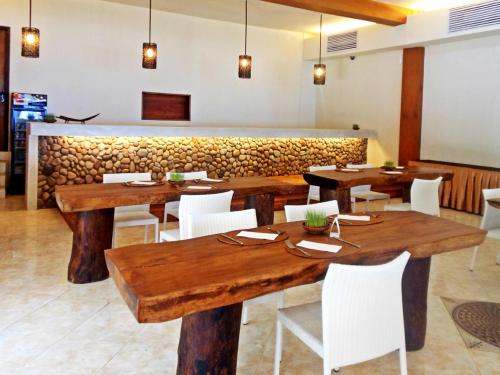 沙璜The Pade Dive Resort的用餐室配有木桌和白色椅子
